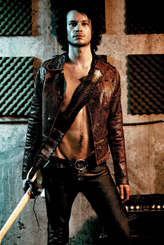 Male model wears hand-made a Lost Art™ Python Snakeskin Jacket, a Lost Art™ Leather Pants, a Lost Art™ Leather Belt and a Lost Art™ Snakeskin Guitar strap
