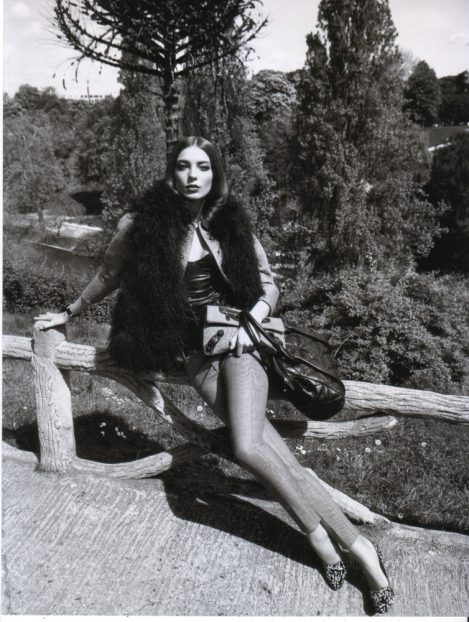 Model Daria Werbowy leaning on a fence, wears a custom-made Lost Art Leather Corset by Jordan Betten in Vogue Paris Magazine circa 2006