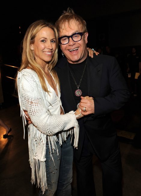 Singer-songwriter Sheryl Crow stands with Singer-songwriter Elton John. Sheryl Crow is wearing a Lost Art woven Leather Fringe Jacket with a Lost Art White Leather Vest, both custom-made by Jordan Betten in New York City circa 2006.